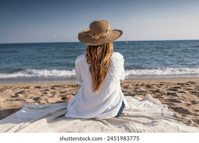 Shot of beautiful young woman sitting on the beach while dreaming and looking at the sea.  - Powered by Shutterstock