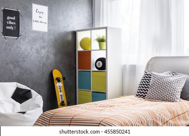 Shot Of A Bedroom Interior With A Single Bed And Colorful Shelf