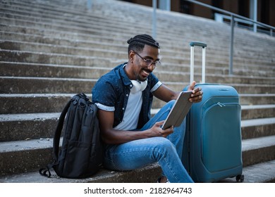 Shot Of A Black Male Using A Tablet Computer Outside Of A Train Station While He Is Waiting