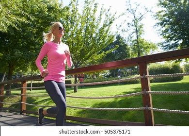 Shot Of A Blond Middle Aged Woman Running Outdoor.