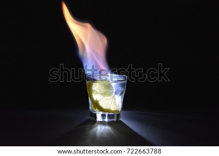 A shot of burning white liquor with a citrus in it