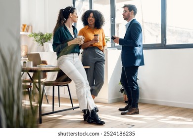 Shot of business people taking a break of work while drinking a cup of coffee in conference room at modern startup - Powered by Shutterstock