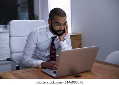 Shot Of A Businessman Working On His Laptop Late At Night. Real Life Businesspeople Shot On Location. Since These Locations Are The Real Thing, And Not Shot In An Office Studio, High ISO Levels Are