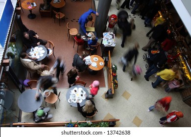 Shot Of A Busy Cafe In A Mall, People All Motion Blurred