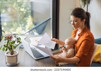 Shot of a busy young mother working while babysitting her daughter at home. - Powered by Shutterstock