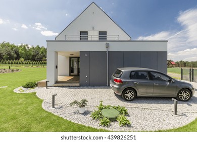 Shot Of A Car Parked In Front Of A White Detached House