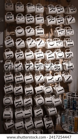 shot of ceramic mugs in a shop with black printd Alphabet letters on it for Name