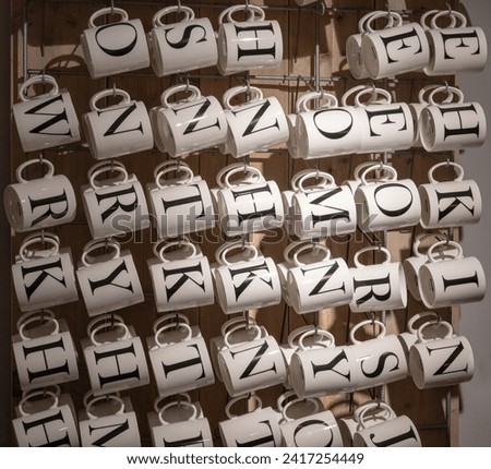 shot of ceramic mugs in a shop with black printd Alphabet letters on it for Name