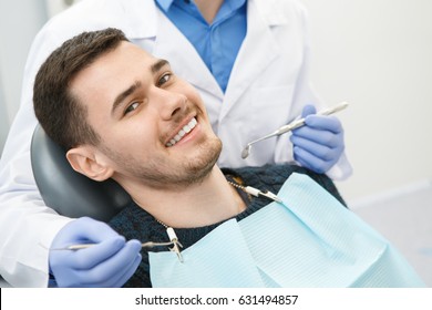 Shot of a cheerful handsome man smiling to the camera sitting in a dental chair his dentist preparing for dental checkup on the background copyspace health medicine people dentistry doctor curing
