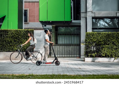 Shot of cheerful woman riding a bicycle crosses a concentrated man on an electric scooter through the city - Powered by Shutterstock