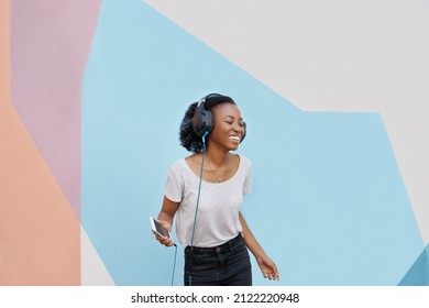 Shot Of A Cheerful Young Woman Dancing Outside And Listening To Music On Her Phone With Her Eyes Closed