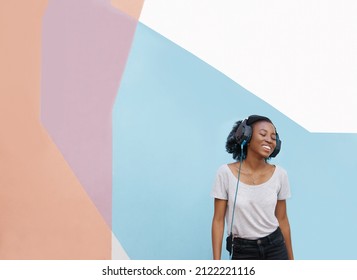 Shot Of A Cheerful Young Woman Dancing Outside And Listening To Music On Her Phone With Her Eyes Closed