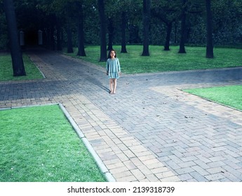 Shot of a child standing in the centre of a four way intersection in the park - ALL design on this image is created from scratch by Yuri Arcurs team of professionals for this particular photo shoot