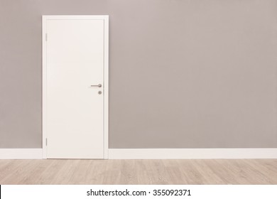 Shot Of A Closed White Door On A Gray Wall In An Empty Room