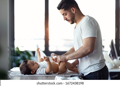 Shot of concentrated young father changing the nappy to his little baby at home. - Powered by Shutterstock