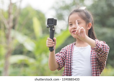 Shot of a confident kid talking on camera in a park she make video blog. child vlogger filming she daily video diary outdoors. kid creating social media content.