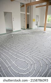 Shot Of Construction Site In A Loft Where Underfloor Heating Has Just Been Installed, White Pipes On Grey Mat