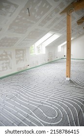 Shot Of Construction Site In A Loft Where Underfloor Heating Has Just Been Installed, White Pipes On Grey Mat