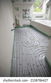 Shot Of Construction Site In A Loft Where Underfloor Heating Has Just Been Installed, White Pipes On Grey Mat