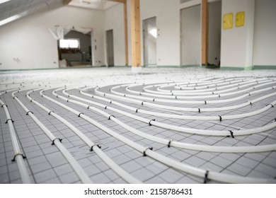 Shot Of Construction Site In A Loft Where Underfloor Heating Has Just Been Installed, White Pipes On Grey Mat