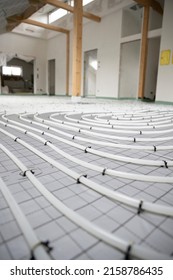 Shot Of Construction Site In A Loft Where Underfloor Heating Has Just Been Installed, White Pipes On Grey Mat