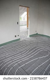 Shot Of Construction Site In A Loft Where Underfloor Heating Has Just Been Installed, White Pipes On Grey Mat