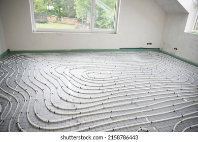 Shot Of Construction Site In A Loft Where Underfloor Heating Has Just Been Installed, White Pipes On Grey Mat