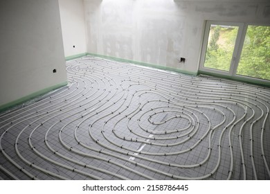 Shot Of Construction Site In A Loft Where Underfloor Heating Has Just Been Installed, White Pipes On Grey Mat