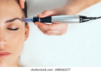 Aufnahme eines Kosmetologen, der eine Mesotherapie-Injektion mit Dermapen im Gesicht zur Verjüngung im Wellnesscenter vornimmt.