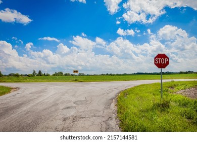 A Shot Of Country Farm Road With Blue Sky And Stop Sign