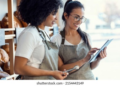 Shot of couple women owners bakery working while analyzing report for order delivery with digital tablet in a pastry shop. - Powered by Shutterstock