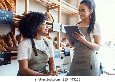 Shot of couple women owners bakery working while analyzing report for order delivery with digital tablet in a pastry shop. - Powered by Shutterstock