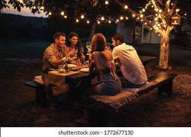 Shot of couples having an outdoor dinner party. Warm tones.