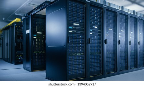 Shot Of Data Center With Multiple Rows Of Fully Operational Server Racks. Modern Telecommunications, Cloud Computing, Artificial Intelligence, Database, Super Computer Technology Concept.