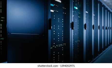 Shot Of Data Center With Multiple Rows Of Fully Operational Server Racks. Modern Telecommunications, Cloud Computing, Artificial Intelligence, Database, Super Computer Technology Concept.