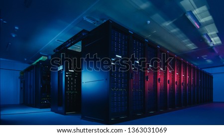 Shot of Data Center With Multiple Rows of Fully Operational Server Racks. Modern Telecommunications, Cloud Computing, Database Concept. Shot in Dark with Neon Blue, Pink L