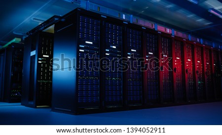Shot of Data Center With Multiple Rows of Fully Operational Server Racks. Modern Telecommunications, Artificial Intelligence, Supercomputer Technology Concept. Shot in Dark with Neon Blue, Pink Lights