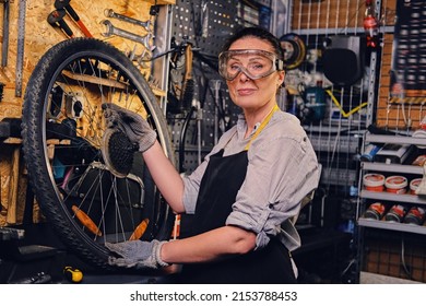 Shot Of Elderly Woman Mechanic Repairing Bicycle Wheel On Workbench In Repair Shop.