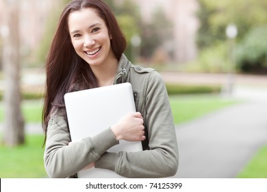 A Shot Of An Ethnic College Student Carrying A Laptop On Campus