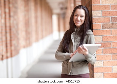 A Shot Of An Ethnic College Student Carrying A Laptop On Campus