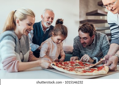 Shot of a family taking slices of pizza - Powered by Shutterstock