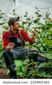 Shot of the farmer using a digital tablet while irrigating his crops, highlighting the scale of his agricultural activities.	