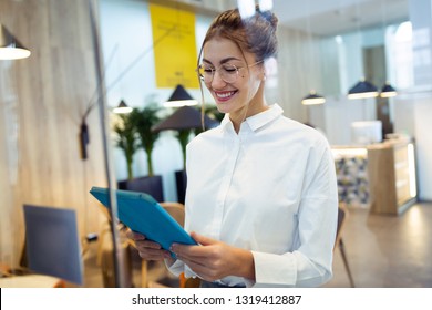 Shot of fashionable young businesswoman working with her digital tablet standing in the hotel lobby. - Powered by Shutterstock