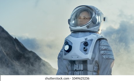 Shot of Female Astronaut in the Space Suit Looking Around Frozen Alien Planet. Advanced Technologies, Space Travel, Colonization Concept.