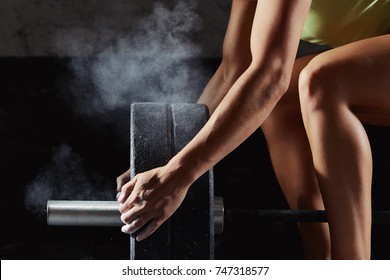 Aufnahme einer weiblichen Sportlerin, die einen Barbell zum Wiegen auf dem Gymnastik-Magnesia-Schutz Kraftheben trainiert, Trainingsvorbereitung mit Fokussierung auf Konzentration