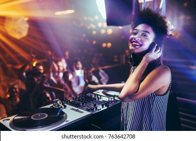 Shot of a female DJ playing music at a nightcub - Powered by Shutterstock