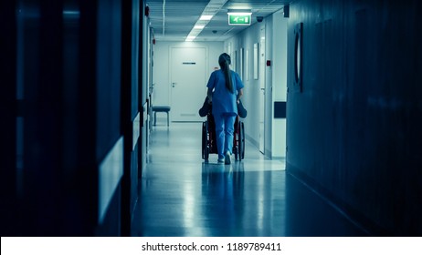 Shot of the Female Nurse Moving Patient in the Wheelchair Through the Hospital Corridor. Doing Procedures. Bright Modern Hospital with Friendly Staff. - Powered by Shutterstock