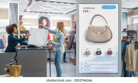 Shot of a Floor-Standing LCD Touch Screen Display with User Interface of Online Clothing Shop Standing in Clothing Store. Self service Checkout. Diverse People in Fashionable Shop Buying Clothes.
