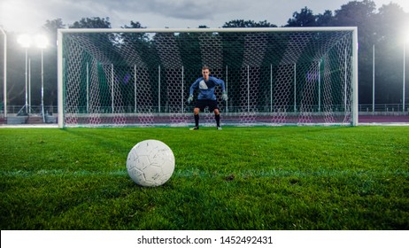Shot of a Football Ball on a Grass during Penalty on Championship. In the Background Professional Goalkeeper Stands in Goals Ready to Defend.