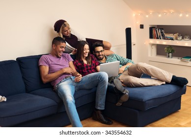 Shot Of A Friends Watching Funny Video On Laptop. Selective Focus On The Closest Person.